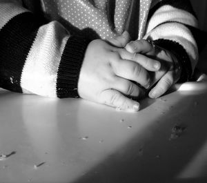 Close-up of baby holding hands on table