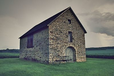 Built structure on field against sky