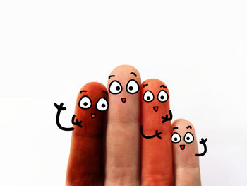 Close-up of hand with toy against white background