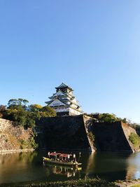 View of built structure by river against clear sky