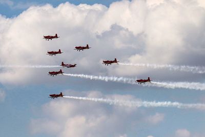 Low angle view of fighter planes flying against sky