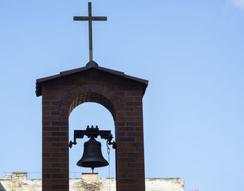 Low angle view of bell tower against blue sky