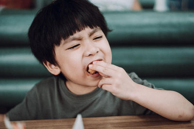 Boy eating ice cream on table