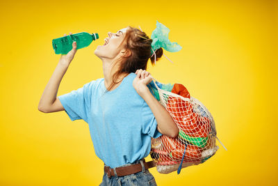 Woman wearing mask against yellow background