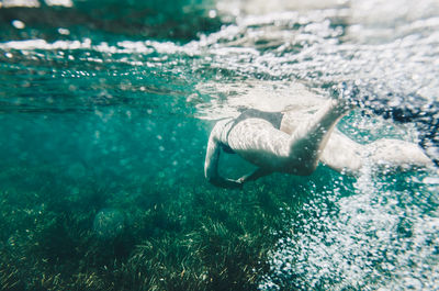 Low section of woman swimming in sea