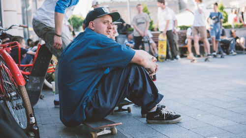 Men sitting on street in city