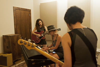 Young woman playing guitar at home