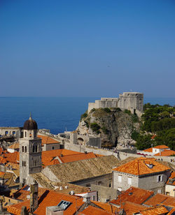 High angle view of townscape by sea against clear sky