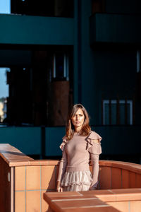 Portrait of smiling woman sitting against wall