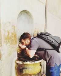 Man drinking water from tap