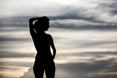 Silhouette woman standing against sky during sunset