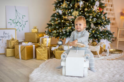 Portrait of cute girl standing by christmas tree