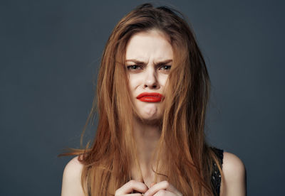 Close-up of young woman against blue background