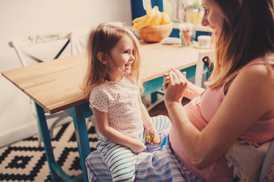 Mother playing with daughter on floor at home