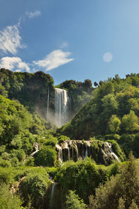 Scenic view of waterfall against sky