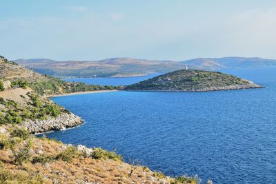 Scenic view of sea and mountains against sky