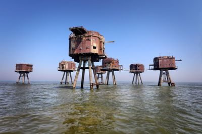 Lifeguard hut on sea against clear blue sky