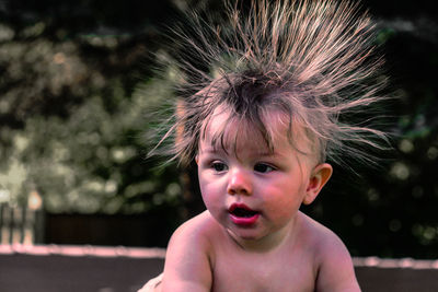 Close-up of cute baby boy with hairstyle