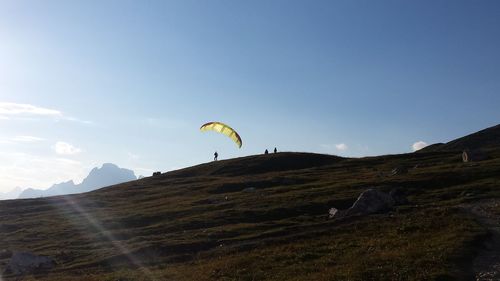 Bird flying over mountain against sky