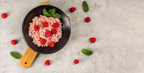 Risotto with raspberries and greek yogurt on grey background.