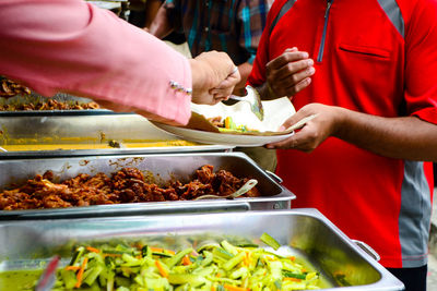 Midsection of man preparing food in restaurant