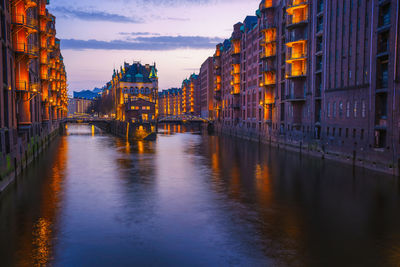 Bridge over river amidst buildings in city