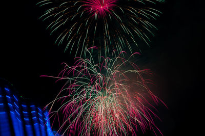 Low angle view of firework display at night