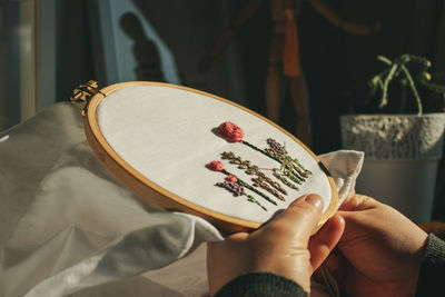 Midsection of person hand embroidering