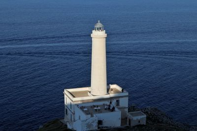 High angle view of lighthouse by sea against building