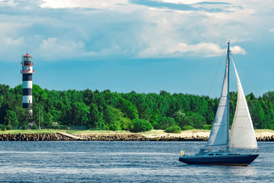 Sailboat sailing on sea against sky