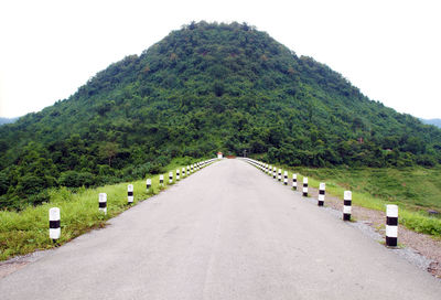 Road amidst trees against sky