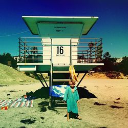 Full length of woman standing against blue sky