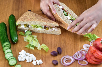 High angle view of woman preparing sandwiches on table