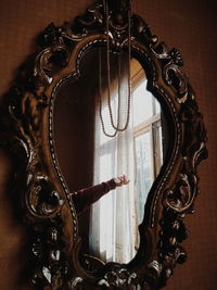 Close-up of hand reflecting in mirror on wall