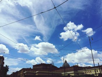 Low angle view of power lines against cloudy sky