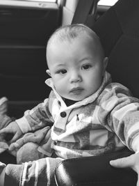 Close-up portrait of cute baby boy sitting in car