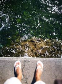 Low section of man standing on water