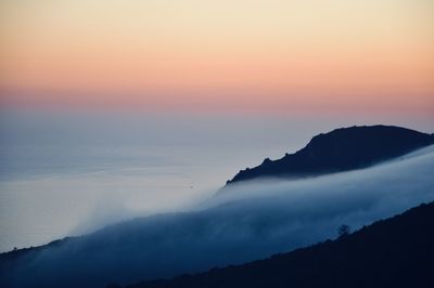 Scenic view of silhouette mountains against sky during sunset