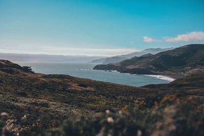 Scenic view of sea and mountains against sky