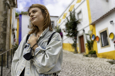 Low angle view of woman standing amidst alley