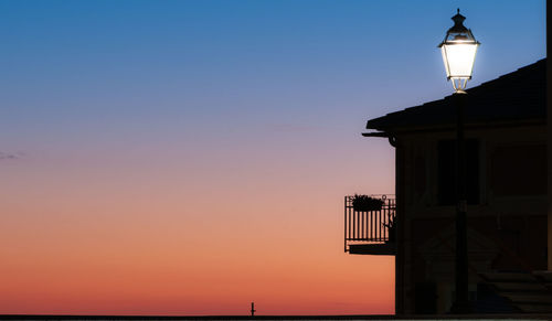 Low angle view of illuminated building against sky during sunset