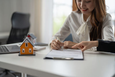 Midsection of businesswoman working on table
