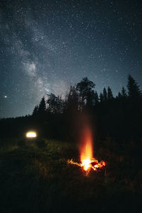 Bonfire on field against sky at night