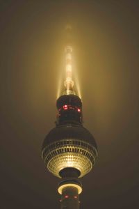 Low angle view of illuminated tower against sky at night