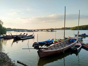 Boats moored at shore against sky