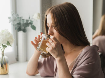 Young woman drinking glass
