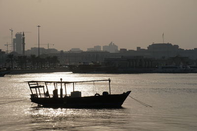 Ship in sea against clear sky during sunset