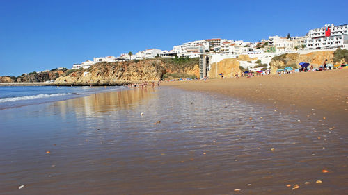 Scenic view of beach against clear blue sky