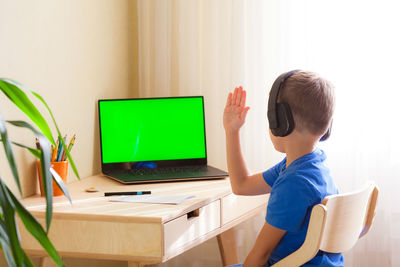 Boy sitting on table at home