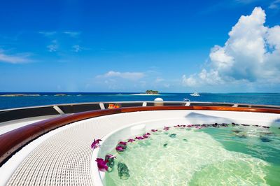 Swimming pool by sea against blue sky